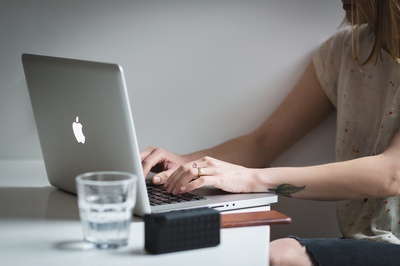 纹身的图片-年轻女子打字MacBook