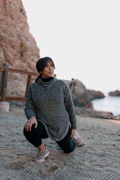 拉伸的图片-女人在晨光下在海滩上练瑜伽