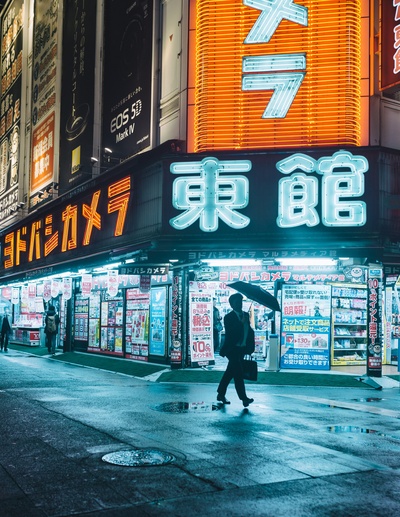 日本的图片-戴着雨伞的男人，被东京霓虹灯挂毯框着。