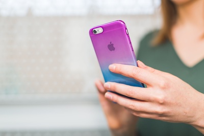 社会化媒体的图片-在渐变iPhone上发短信的女人