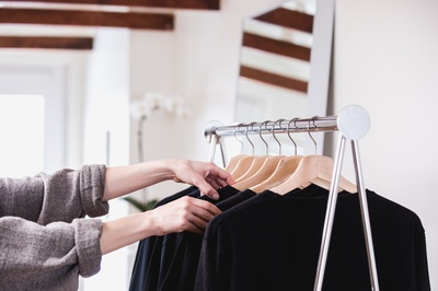 Shop Local的图片-在阳光明媚的商店里比较衣服架上的黑色T恤