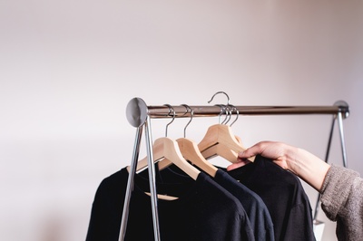 Shop Local的图片-一只手从衣架上取下一件毛衣。