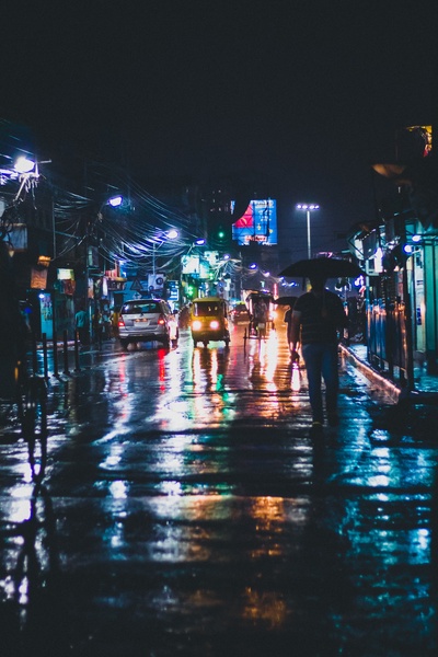 雨的图片-路灯反射在印度潮湿的城市街道上