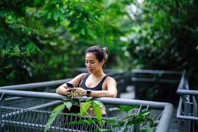 人与植物的图片-穿运动胸罩看电话的女人
