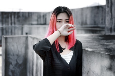 生活时尚的图片-站在水泥墙上的粉红色头发女人