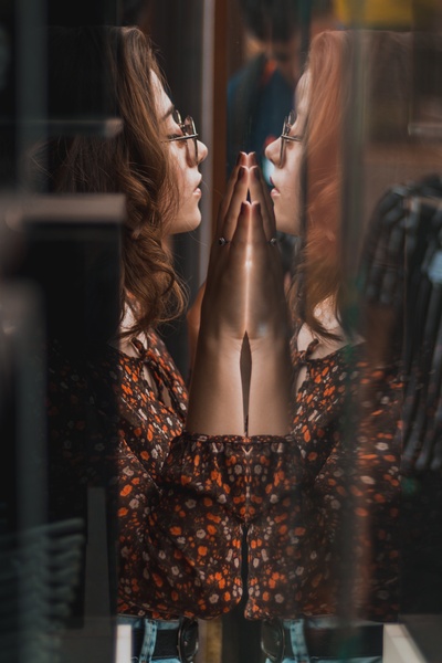 反思的图片-双手放在玻璃墙上的女人