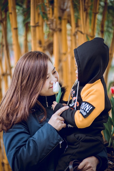 母亲节快乐的图片-手上拿着白花幼儿的女人