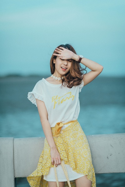流行服饰的图片-穿白色和黄色大圆领迷你连衣裙的女人