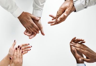 把手放在镜框里的图片-四个人拍手示意