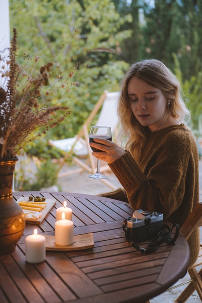 情人节快乐的图片-拿着酒杯靠近桌子的女人