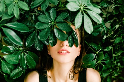 妒忌绿的图片-在绿叶植物旁穿黑上衣的女人