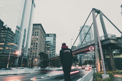 城市生活的图片-穿黑色连帽衫的男人看着高速公路