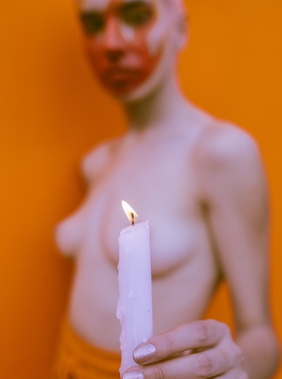 叛逆，你的脸一团糟的图片-无上装妇女手持白蜡烛的浅焦摄影