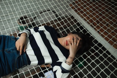 叛逆，你的脸一团糟的图片-穿黑白条纹长袖上衣的女人躺在黑网上