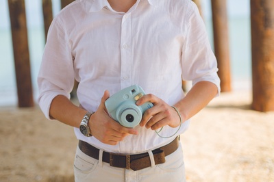 收集记忆的图片-男人拿着蓝色的Fujufilm Instax迷你相机