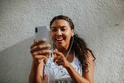 技术的图片-女人靠在墙上微笑着使用银色iPhone X