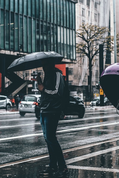雨天的图片-拿着黑伞的人