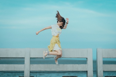 感到快乐的图片-白黄相间的女子在水体附近的跳投摄影