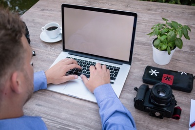 模仿的图片-在数码单反相机旁使用MacBook Pro的人