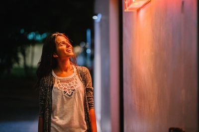 夜间的图片-穿灰色羊毛衫的女人晚上站在墙边