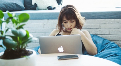 千禧年文化的图片-穿黑色背心的女人用银色MacBook