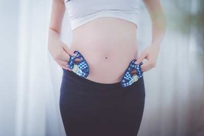 怀孕的图片-孕妇把婴儿鞋放在肚子里