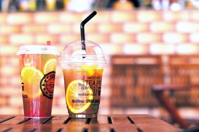 新鲜液体的图片-棕色木桌上的两个塑料杯