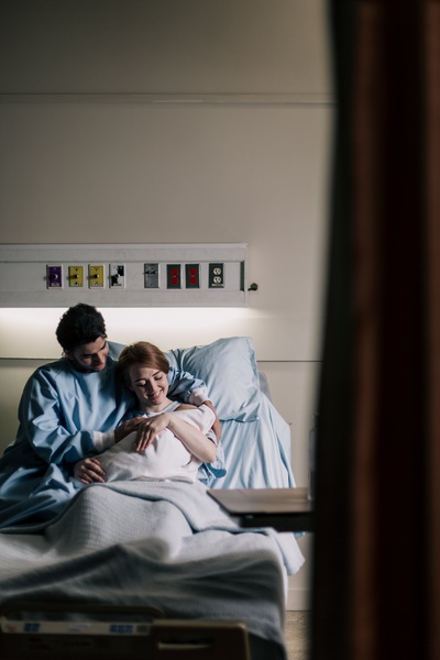 Feel Good Photos的图片-父母抱着新生儿躺在病床上
