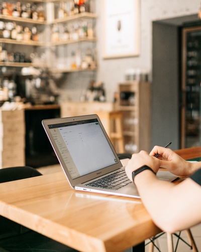 2019冠状病毒疾病的图片-在棕色木桌上使用macbook air的人