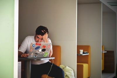 商务工作的图片-穿白色上衣的男人用MacBook