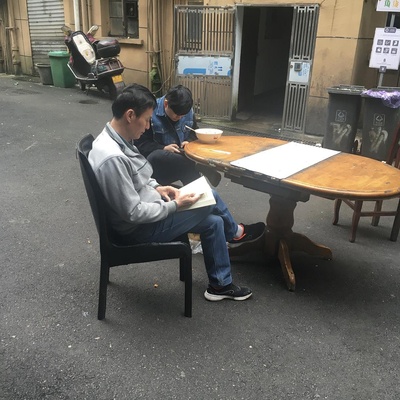 现实中让你感受最为深刻的阅读场景的图片-一个大哥在等早餐的时候看王安石的传记，粉端上来了就一把把书垫了。