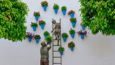 正在照看花草的孩子和祖父铜雕，西班牙科尔多瓦 (© David M G/Alamy)(20200505)的图片-正在照看花草的孩子和祖父铜雕，西班牙科尔多瓦 (© David M G/Alamy)