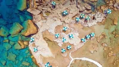 鸟瞰希腊罗德岛岩石海岸上蓝白相间的遮阳伞 (© Amazing Aerial Agency/Offset by Shutterstock)(20200624)的图片-鸟瞰希腊罗德岛岩石海岸上蓝白相间的遮阳伞 (© Amazing Aerial Agency/Offset by Shutterstock)